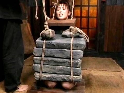 日本古来の女囚人拷問！首枷を着けられ、木の上に正座させらた女囚の膝の上に重い石が重ねられる！