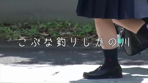 魅力的な若い女性が、小奇麗な女学生の制服を着て賞賛している。