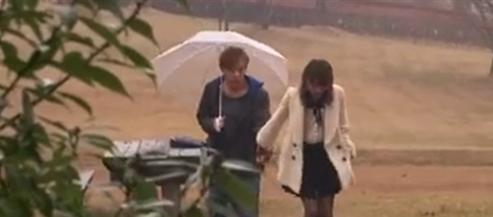 イケメン男性に女性が雨の中口説きかかる。